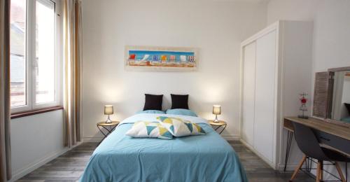 a bedroom with a bed with a blue bedspread at " Le Léana Cardi " Fécamp Bord de mer in Fécamp