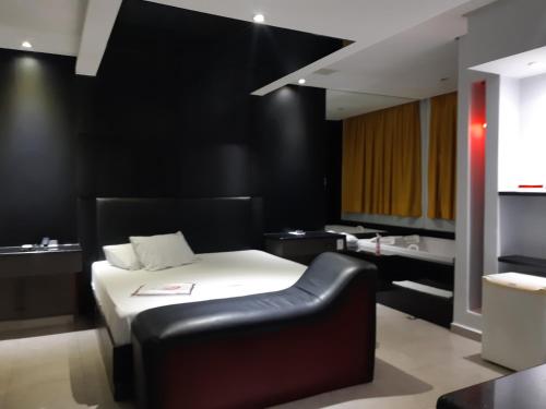 een slaapkamer met een bed en een zwarte muur bij Impulse Motel in São Bernardo do Campo