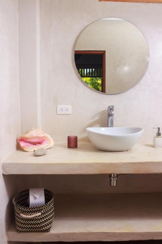 a bathroom with a sink and a mirror at Casa Chapolin Boutique Guesthouse in Palomino