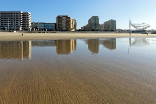 een uitzicht op een strand met gebouwen op de achtergrond bij Apartamento Mira Foz in Matosinhos