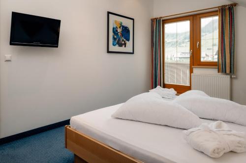 a bedroom with two beds and a tv on the wall at Haus Anemone in Serfaus