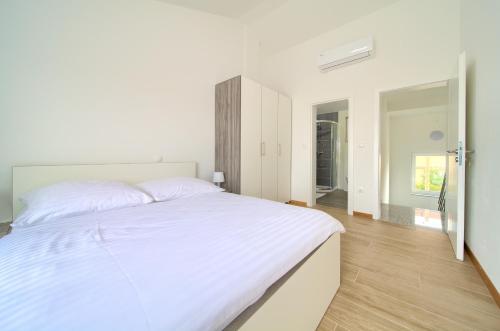 um quarto branco com uma grande cama branca em Adria House em Sveti Anton