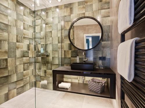 La salle de bains est pourvue d'une douche et d'un miroir. dans l'établissement Hotel Erasmus - Mein Genuss- und Wellnesshotel, à Trassem
