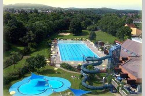 an aerial view of a large swimming pool with a water slide at Gemütlicher Ferienbungalow in Frankenau, kostenloses WLAN in Frankenau