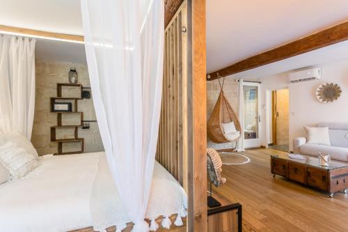 um quarto com uma cama de dossel e uma sala de estar em My Pad Provence 6 em Avignon