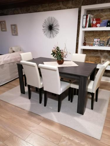 a dining room with a black table and white chairs at Quinta Rural - Nossa Sra do Carmo. Teixoso in Teixoso