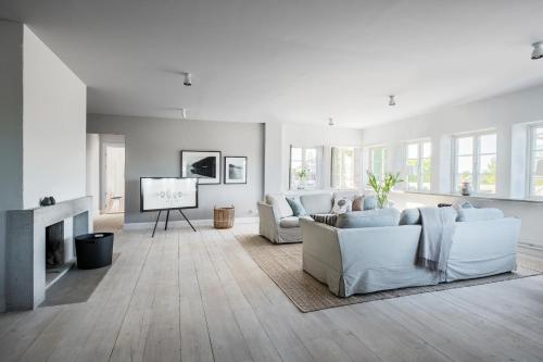 a living room with white furniture and a flat screen tv at Sands Hotell in Sandhamn