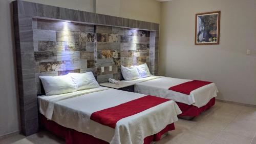 Habitación de hotel con 2 camas y pared en Hotel Mediterraneo, en Ciudad Madero
