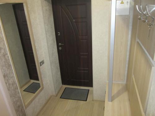 a hallway with a brown door and a mirror at Luxuri apartments in Chernihiv