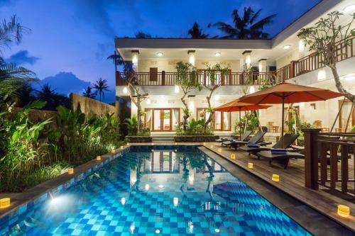 uma villa com piscina à noite em Puri Payogan Villa em Ubud