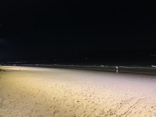 a person standing on a beach at night at Recanto da Sol in Florianópolis