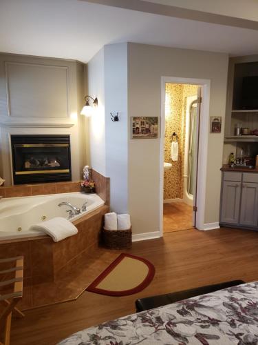 a bathroom with a bath tub and a fireplace at 627 on King B&B in Niagara on the Lake