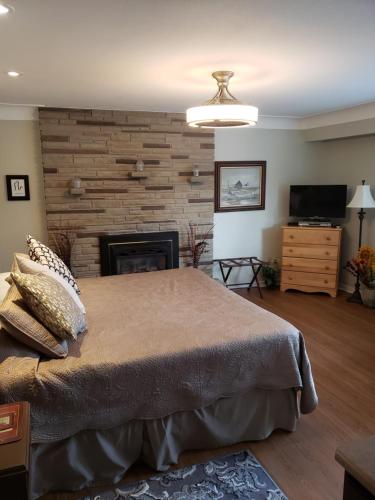 a bedroom with a large bed and a fireplace at 627 on King B&B in Niagara on the Lake