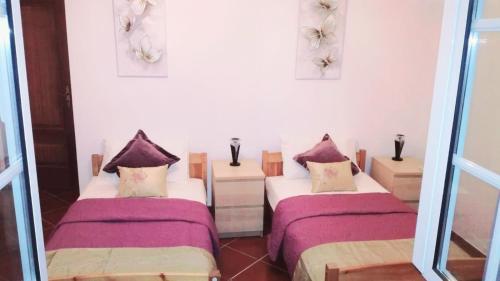 2 Betten in einem Zimmer mit lila Bettwäsche in der Unterkunft Quinta do Sobreiro, 4 bedroom Modernised Farmhouse in Tomar