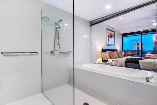 1 cama y baño con ducha y bañera. en Circle on Cavil Holidays Gold Coast, en Gold Coast