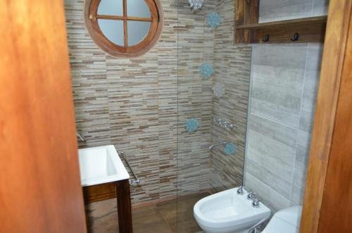 a bathroom with a toilet and a sink and a mirror at Complejo de Cabañas lo de Otto , Los Acantilados , Mar del plata in Mar del Plata