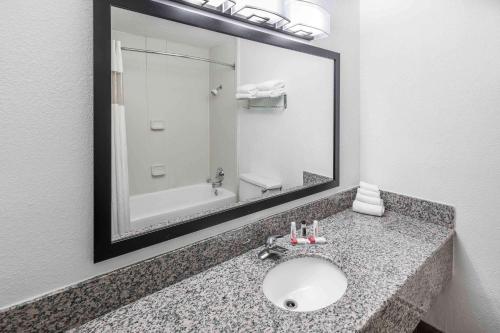 a bathroom with a sink and a large mirror at Howard Johnson by Wyndham Beaufort/Parris Island in Beaufort