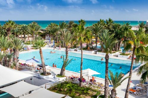 an overhead view of a pool with palm trees and the ocean at Palm Beach Club Djerba - All Inclusive in Midoun
