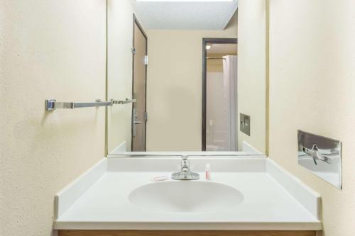 Super 8 by Wyndham Ottawa Starved Rock في أوتاوا: حمام مع حوض ومرآة