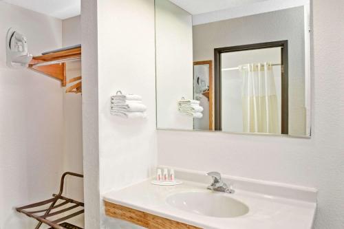 La salle de bains blanche est pourvue d'un lavabo et d'un miroir. dans l'établissement Super 8 by Wyndham Mokena/Frankfort /I-80, à Mokena