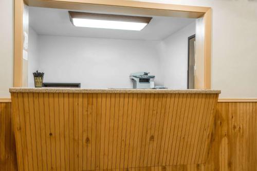 a wooden bar in an office with a mirror at Super 8 by Wyndham Fergus Falls in Fergus Falls