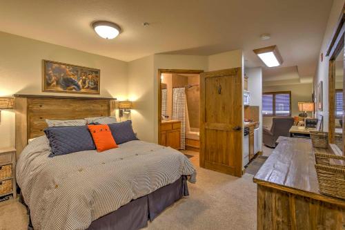 a bedroom with a bed with an orange pillow on it at Walk to Ski Slopes and Main St Cozy Breck Condo! in Breckenridge