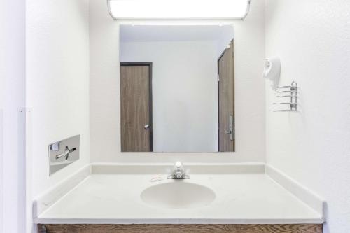 a white bathroom with a sink and a mirror at Super 8 by Wyndham Elgin in Elgin