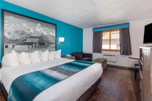 a hotel room with a large bed and a couch at Super 8 by Wyndham Gardiner/Yellowstone Park Area in Gardiner