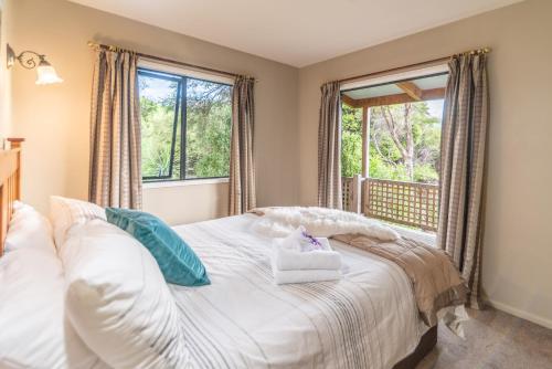 um quarto com uma cama e uma janela em Overton Cottage - Akaroa Holiday Home em Akaroa