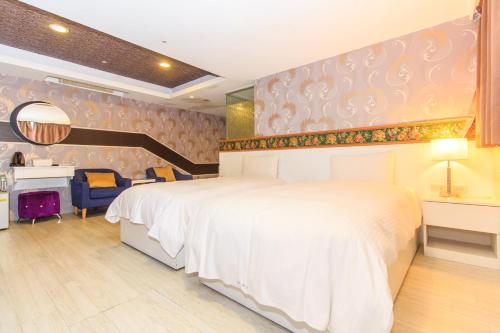 a bedroom with a large white bed and a desk at 幸福星空時尚旅館 in Luodong