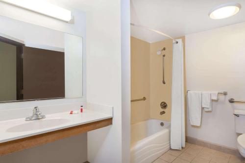 y baño blanco con lavabo y ducha. en Super 8 by Wyndham Harrisburg Hershey West, en Harrisburg