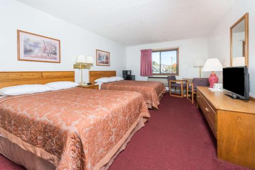 a hotel room with two beds and a flat screen tv at Super 8 by Wyndham Front Royal in Front Royal