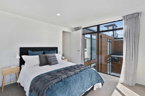 ein Schlafzimmer mit einem Bett und einem großen Fenster in der Unterkunft Urban Diamond in Christchurch