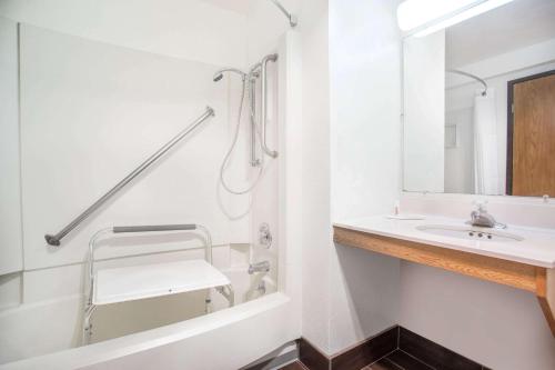 uma casa de banho branca com um lavatório e um chuveiro em Super 8 by Wyndham Lacey Olympia Area em Lacey