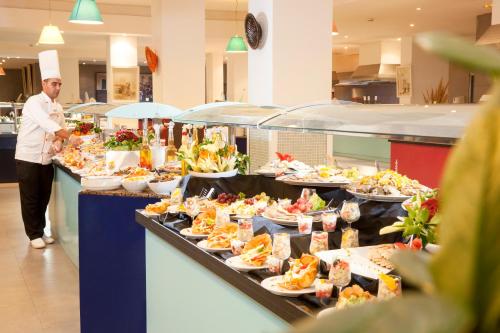 a buffet line with plates of food in a restaurant at Palm Beach Club Djerba - All Inclusive in Midoun