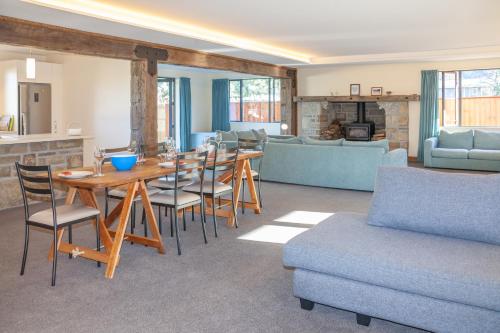 a living room with a table and chairs and a couch at GraceWorks - Hanmer Springs in Hanmer Springs