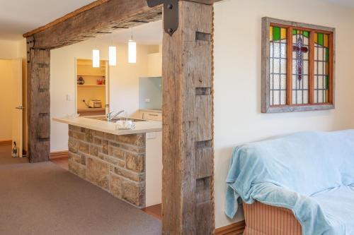 a bedroom with a stone wall next to a bed at GraceWorks - Hanmer Springs in Hanmer Springs