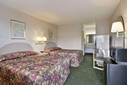 a hotel room with a bed and a refrigerator at Days Inn by Wyndham Cartersville in Cartersville