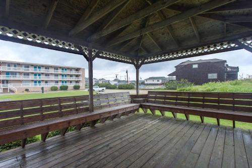 a wooden bench on a deck with a view of a building at Mariner Inn And Suites in Kill Devil Hills