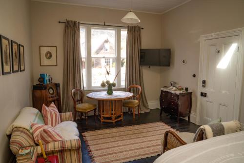 a living room with a table and chairs and a window at Villa Akaroa - Akaroa Pet Friendly Holiday Home in Akaroa