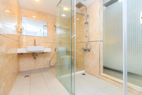 a bathroom with a glass shower and a sink at 幸福星空時尚旅館 in Luodong
