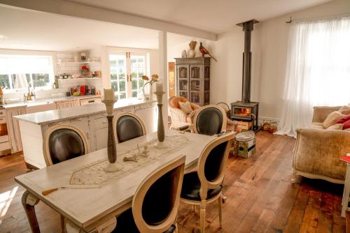 a living room with a table with chairs and a stove at Villa Akaroa - Akaroa Pet Friendly Holiday Home in Akaroa