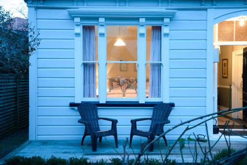 two chairs sitting in front of a window at Villa Akaroa - Akaroa Pet Friendly Holiday Home in Akaroa