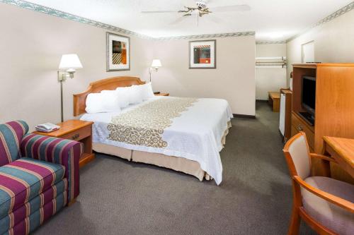 a hotel room with a bed and a couch at Days Inn by Wyndham Batesville in Batesville