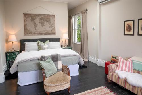 a bedroom with a large bed and a chair at Villa Akaroa - Akaroa Pet Friendly Holiday Home in Akaroa