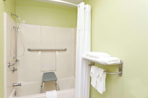 een badkamer met een douche, een bad en handdoeken bij Days Inn by Wyndham Springfield in Springfield