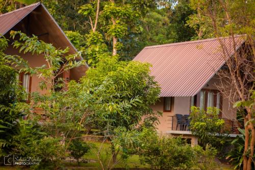 een huis met een metalen dak en bomen bij Hantara Udawalawa in Udawalawe