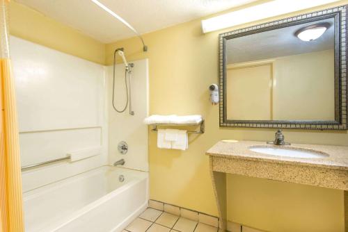 W łazience znajduje się umywalka, wanna i lustro. w obiekcie Days Inn by Wyndham Shorter w mieście Shorter