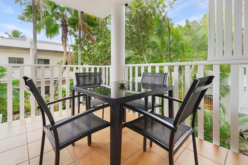 a black table and chairs on a balcony at Outrigger Apartments Port Douglas in Port Douglas