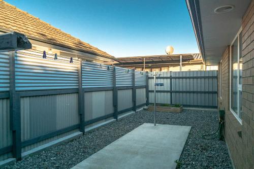an empty backyard with a fence and a sidewalk at Central on Keiss - Blenheim Holiday Home in Blenheim